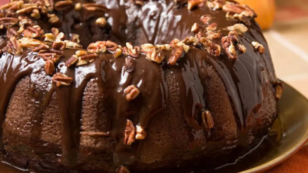 Delicious Chocolate pound cake on a plate, featuring rich and dense chocolate, covered with a light layer of melted chocolate and decorated with caraway chips.